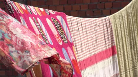 washed blankets hanging on a clothes line to dry in the sunshine