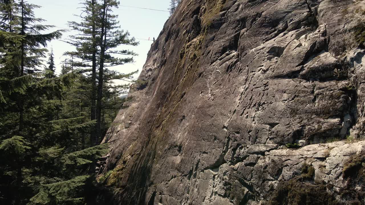 imágenes de drones de un acantilado con personas escalando en el fondo en squamish en bc, canadá