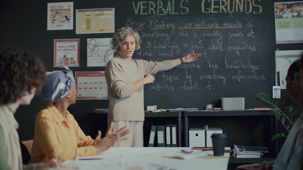 Professora Explicando a Forma Gerúndio do Verbo aos Alunos na Aula de Inglês