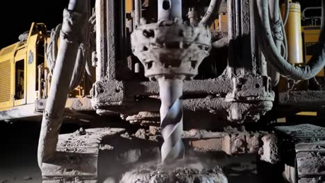 high-resolution focus on heavy-duty drilling equipment in action, showcasing the rotating drill bit engaged in dense material on a construction site