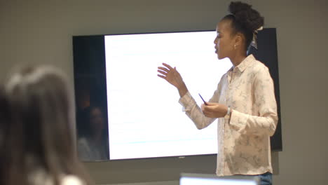 Young-African-American-woman-presents-in-a-modern-business-office-setting