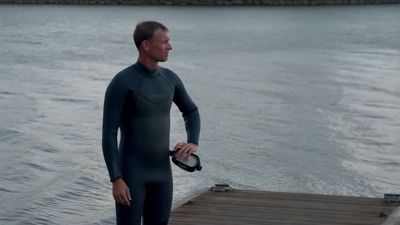 Man in Wetsuit on a Dock with Diving Mask