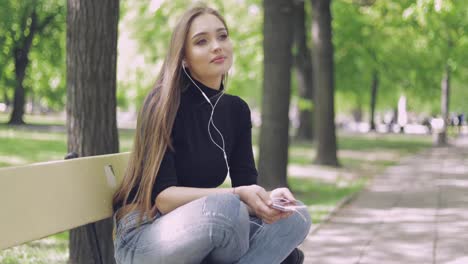 Pretty-female-with-smartphone-on-bench