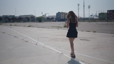 woman walking with tablet in an empty industrial area