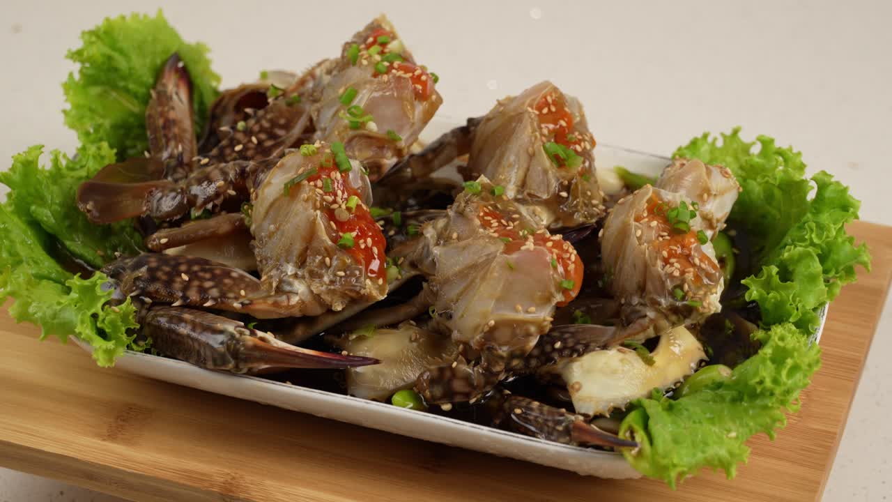 Tender raw crab soaked in savory soy sauce, infused with sesame and spices for rich flavor. 간장에 숙성된 신선한 꽃게, 참깨와 양념이 어우러져 깊은 맛을 내는 별미.