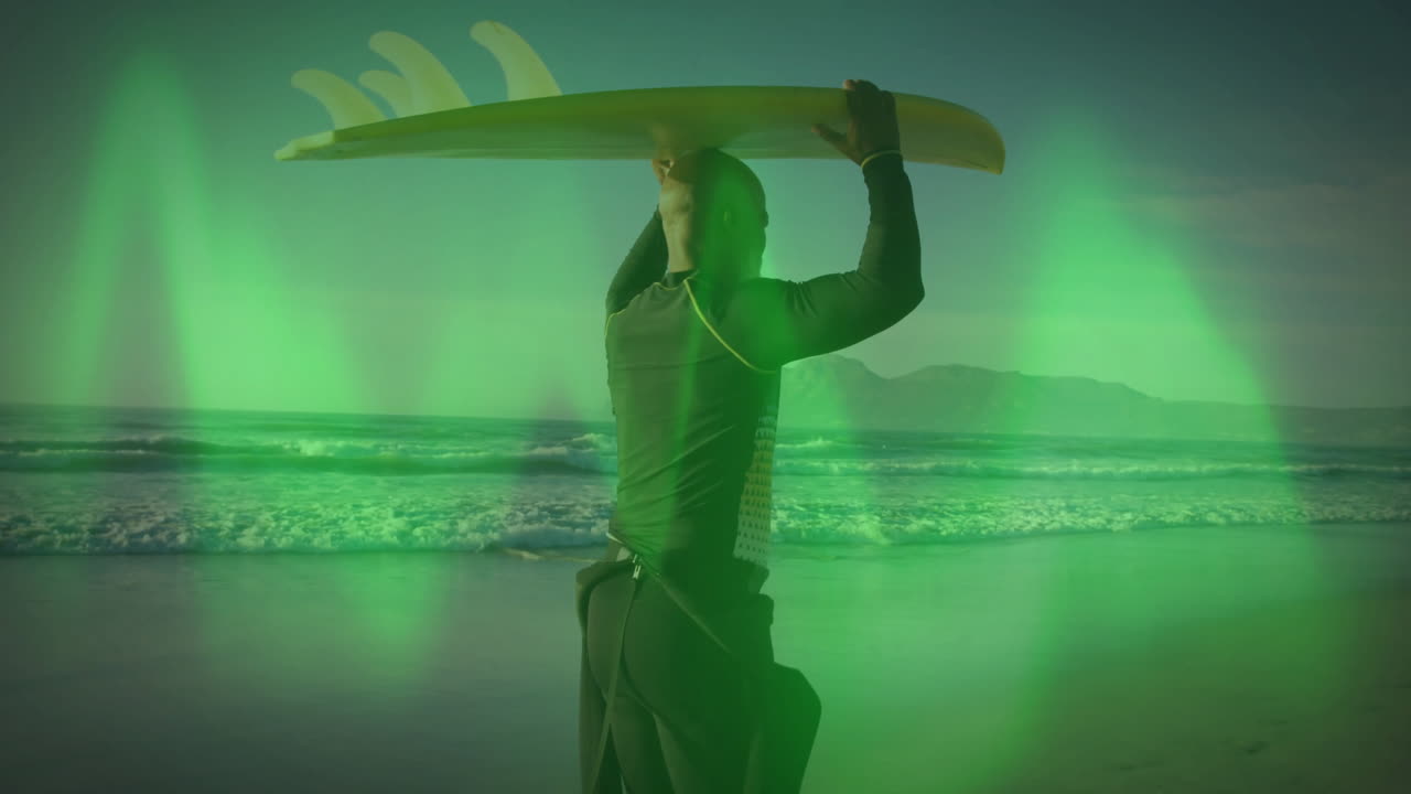 Surfer holding board over head with green light animation on beach