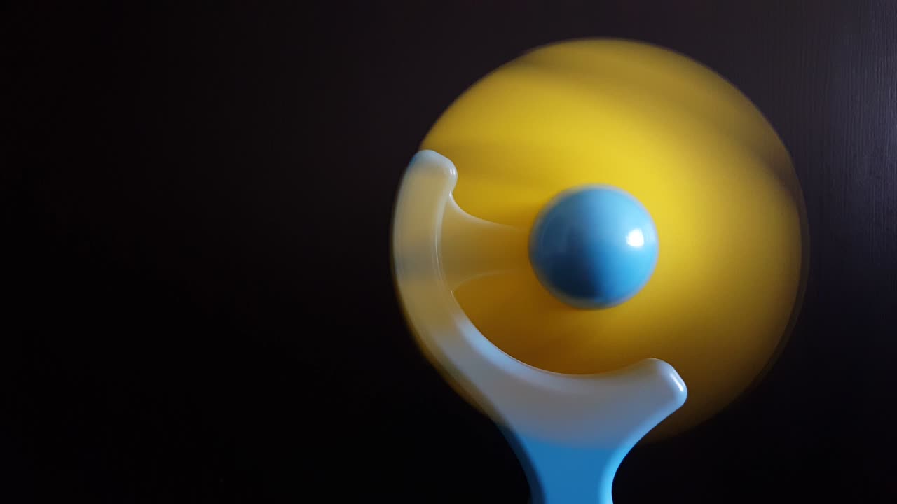 hombre encendiendo y apagando un mini ventilador de plástico sobre un fondo negro