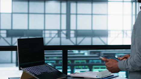 técnico en un centro de datos con portátil y tableta que integra tecnología de ia
