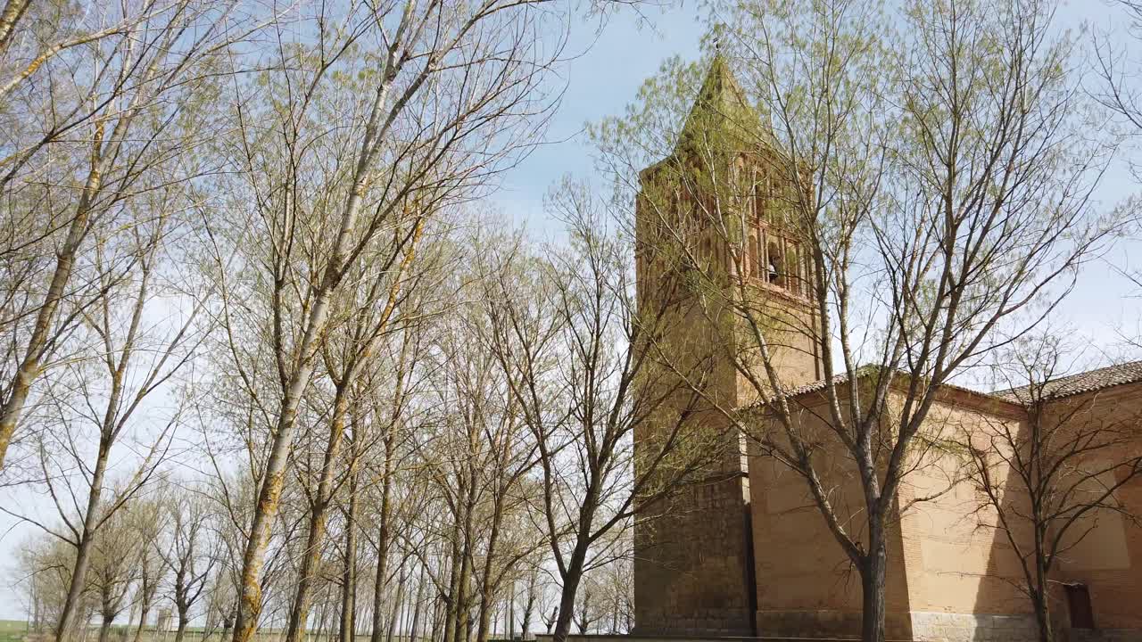 푸른 하늘과 함께 스페인 교회 주위의 봄 나무