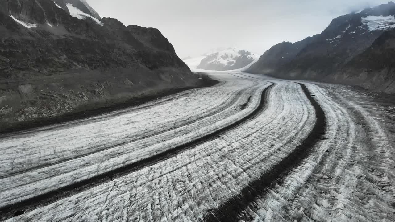 Aerial flyover over the longest glacier in the Alps - the Aletsch glacier in Valais, Switzerland - while backing away from Jungfrau