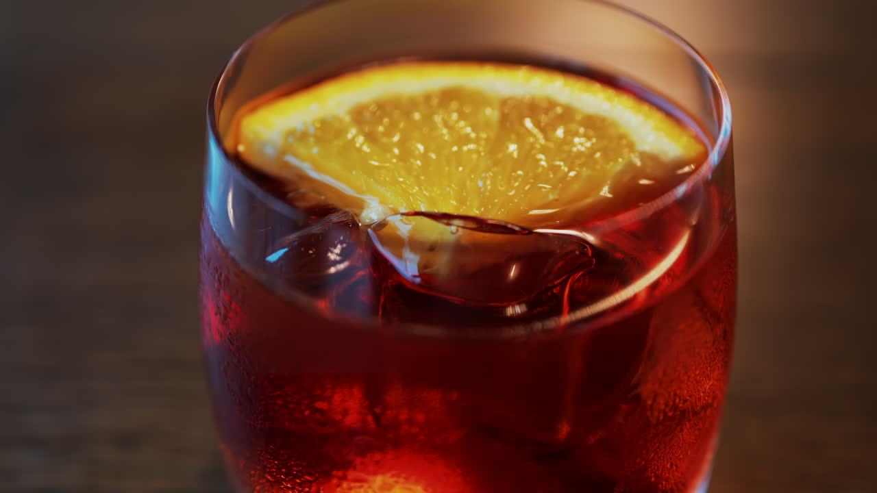 Primo piano di un cocktail Negroni con fetta d'arancia e cubetti di ghiaccio su un tavolo di legno