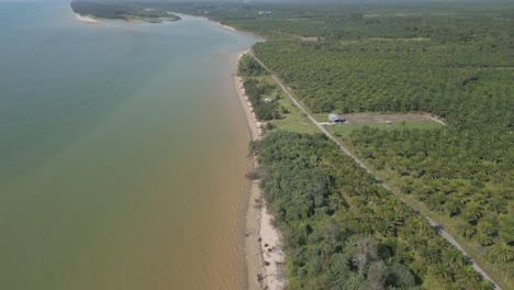 aerial drone view during summer alit fishing village,kabong with, facing open blue sea, white sandy beach,green coconut, palm trees,and river,sarawak,borneo