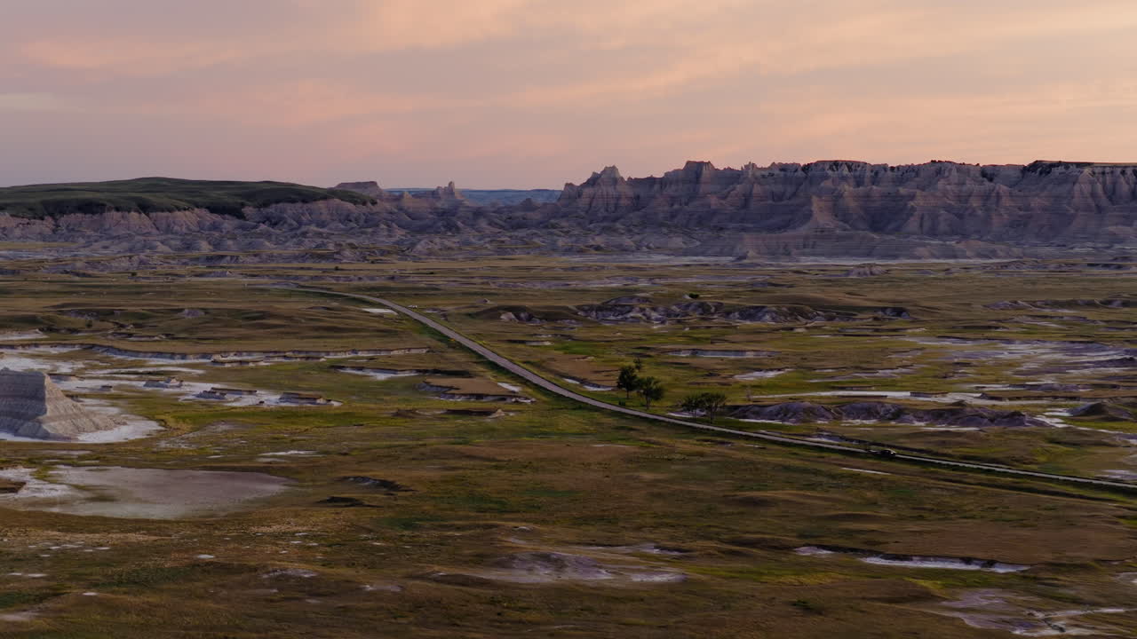 Scenic Highway Through Jagged Badlands Peaks in Stunning Sunset Aerials