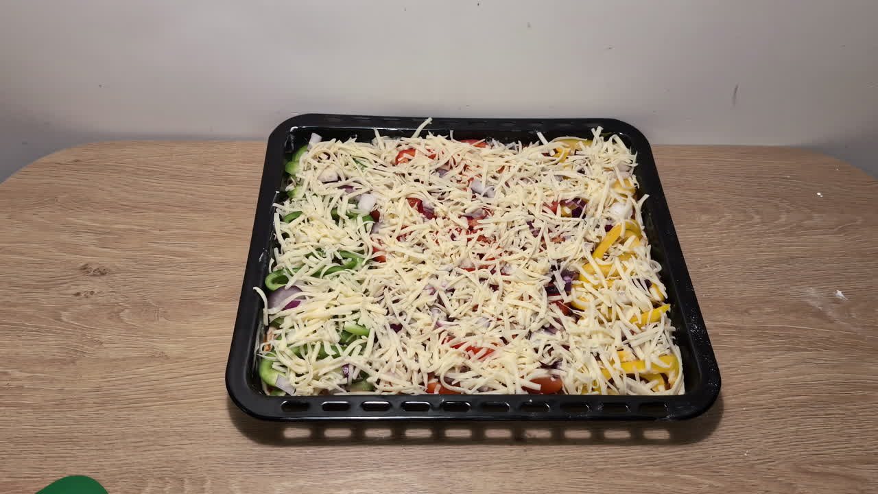 manos tomando una pizza sin cocinar con queso y ingredientes en un mostrador de la cocina, listo para hornear