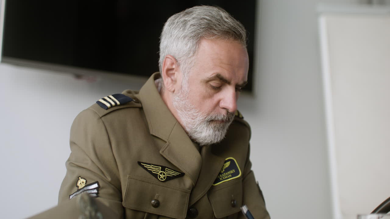 Mature man in uniform writing