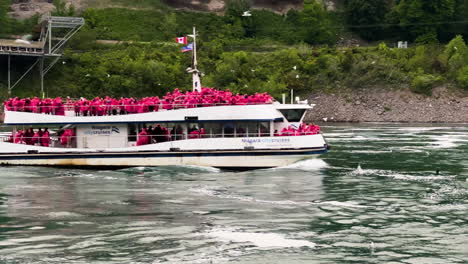 people in red raincoats aboard on ship cruising to the niagara falls