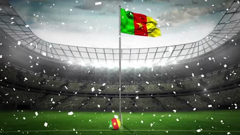 animation of camera flashes and confetti falling over waving cameroon flag against sports stadium