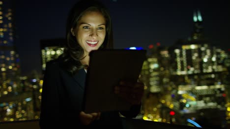 una gerente latinoamericana usando una tableta por la noche.