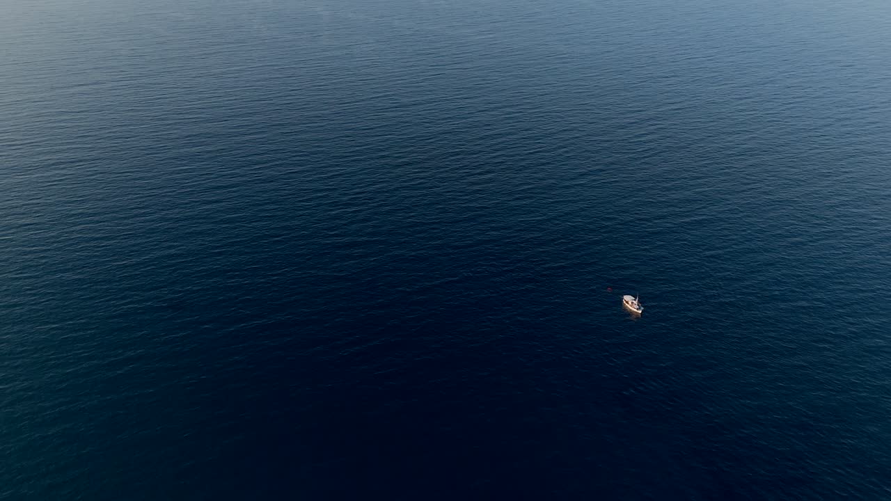 그리스 크레타 근처의 넓고 조용한 푸른 바다에서 떠다니는 작은 배
