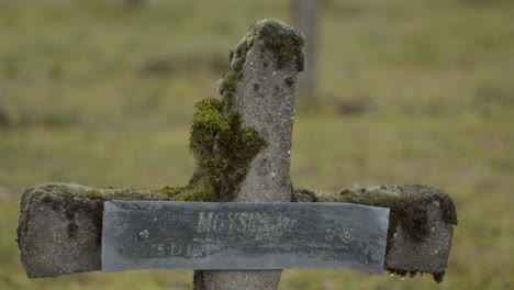 static close up of old and broken crucifix at graveyard