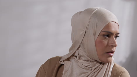 close up of muslim woman wearing hijab at home standing and praying