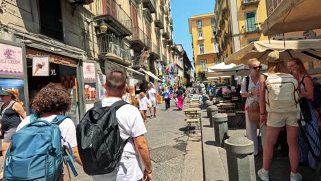 people walking through a vibrant naples street market