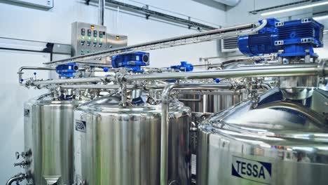 contemporary milk making factory indoors. huge bowls for mixing milk and water. special equipment for preparing cheese.