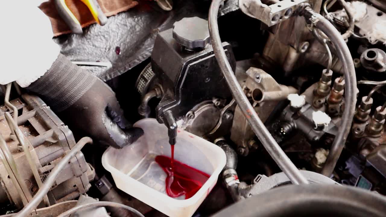 Mechanical Guy Draining Hydraulic fluid reservoir Of Diesel Engine ...