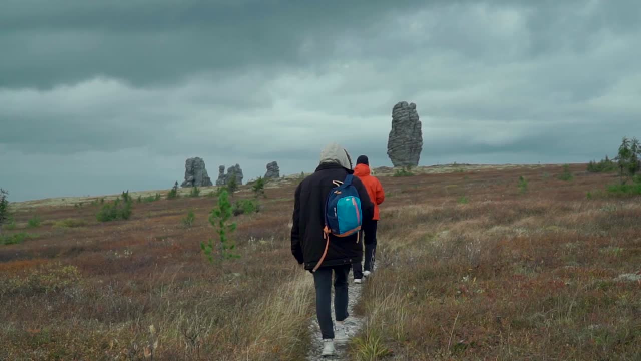 excursionistas en un sendero en medio de formaciones rocosas únicas en el otoño