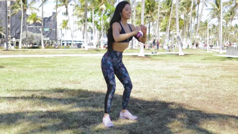 chica deportiva contenta en cuclillas en el parque