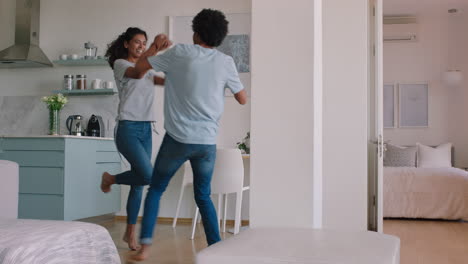 happy young couple dancing at home enjoying funny dance having fun celebrating
