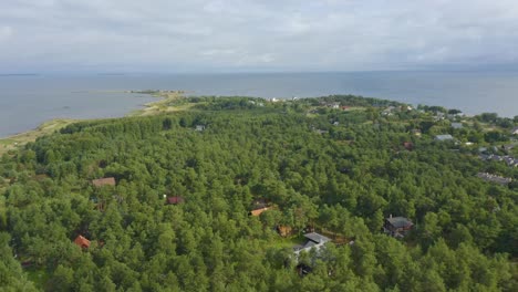 Drone-En-Movimiento-Lento-De-Un-Pueblo-Estonio-En-El-Bosque-Junto-Al-Mar