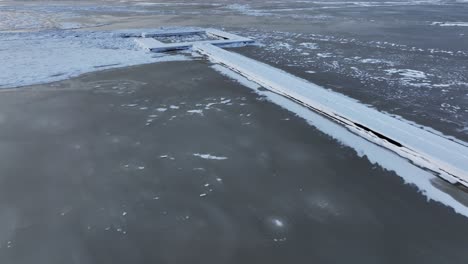 un muelle nevado y congelado que conduce a la laguna de curonian, que está congelada en invierno