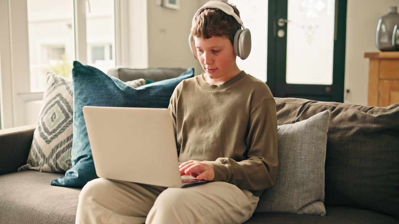 Boy learning with a laptop and headphones at home