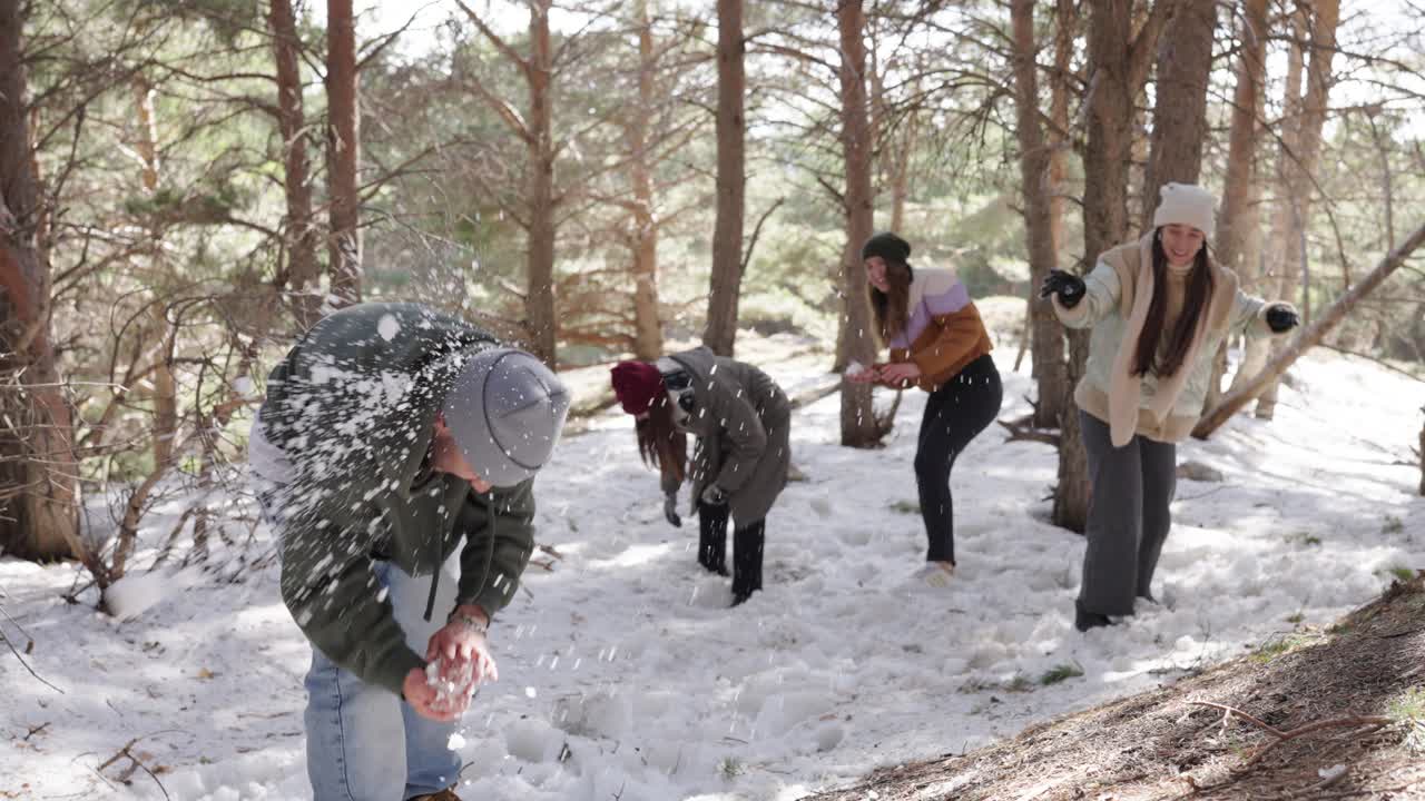 Group of Friends Having a Snowball Fight in the Forest