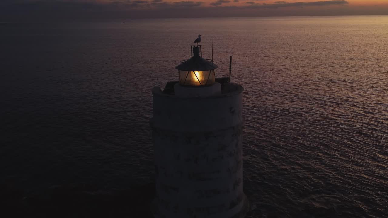 Wonderful aerial drone shot of solitary Lighthouse with seagull on top, dusk