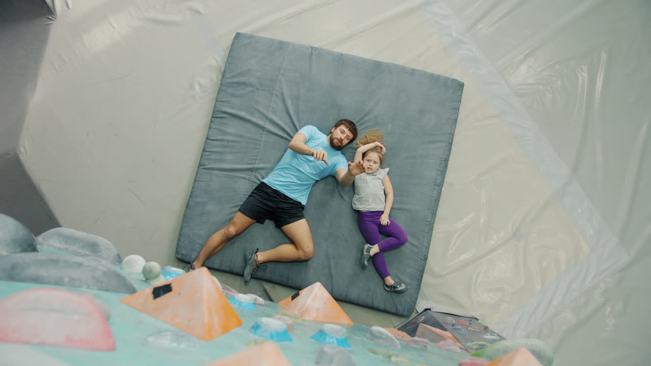 Father and daughter relaxing in climbing gym