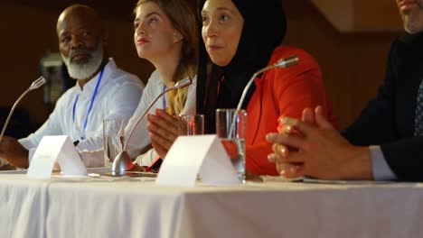 Businesswoman-speaking-in-speaker-at-table-in-auditorium-4k