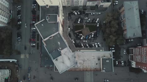 aerial view of a city block with apartment buildings and parking