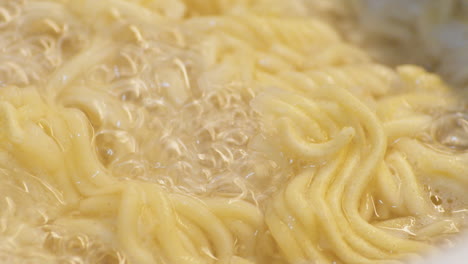 instant ramen noodles cooked in a boiling water with bubbles