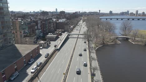 Aerial-of-Storrow-Drive-traffic-along-Charles-River,-riverfront-Boston