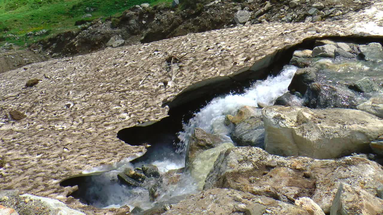 Neve che si scioglie copre una cascata.
