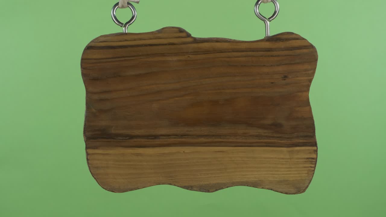 줄에 매달린 오래된 나무 표지판의 파노라마. 초록색 배경에 고립되어 있습니다.