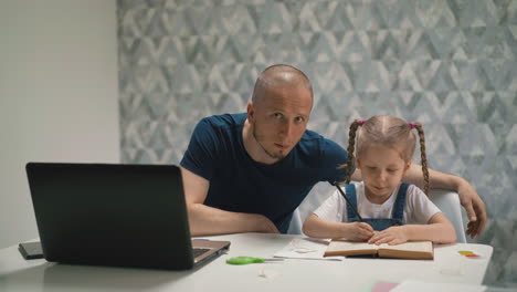 dad-look-little-blond-daughter-doing-homework