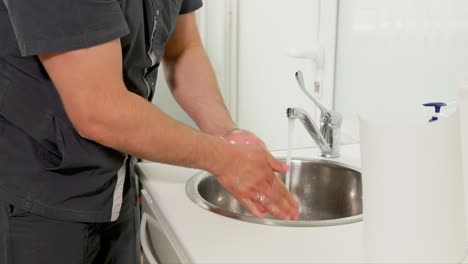 person washing hands in hospital/clinic setting
