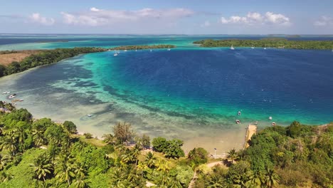 vava'u, tonga - a picturesque view of a turquoise-water tropical island with boats anchored along the shoreline - drone flying forward