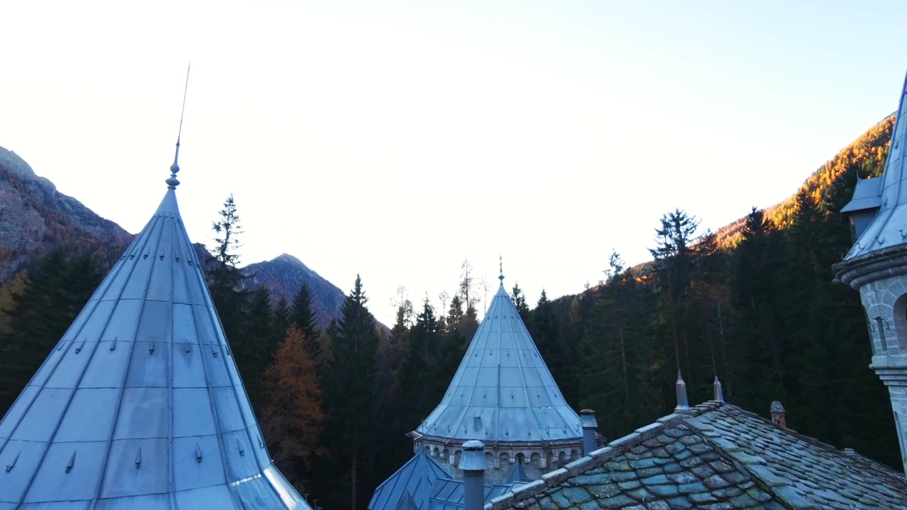 Savojský hrad, Gressoney, Itálie – Historický hrad se špičatými věžemi majestátně stojí uprostřed alpské krajiny – Dron letící vpřed