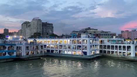 Passenger-ships-moored-at-terminal-of-Buriganga-River-at-evening-in-Sadarghat,-Dhaka,-Bangladesh