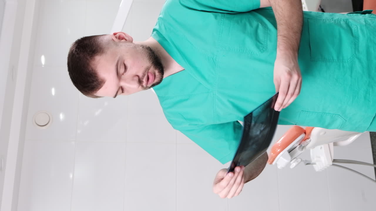 Doctor in the dental office checking and explaining x-ray test, vertical screen