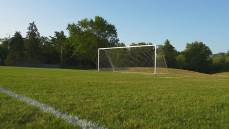 Ein-Breiter,-Niedriger-Winkelwagen-Eines-Leeren-Fußballfeldes-An-Einem-Sonnigen-Sommermorgen